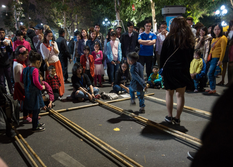 people playing a game with bamboo poles