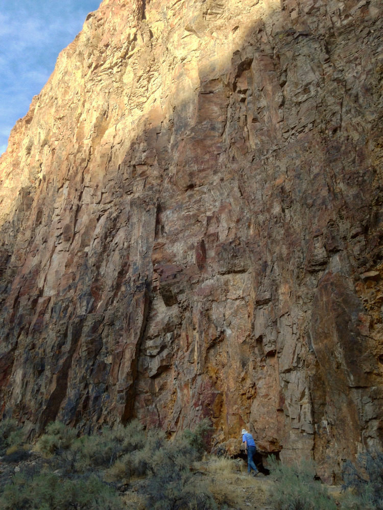 Tom at the base of a tall rock wall