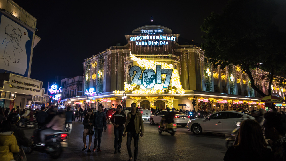 busy streetcorner in front of a large 2017 sign