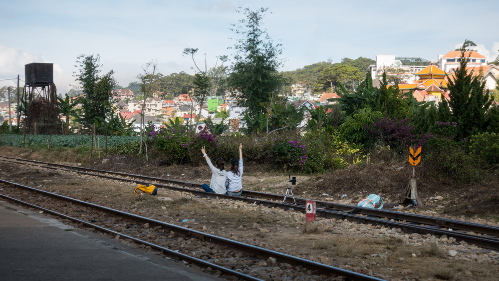 women posing on train tracks