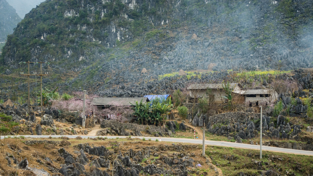 houses and cooking smoke in front of rocks