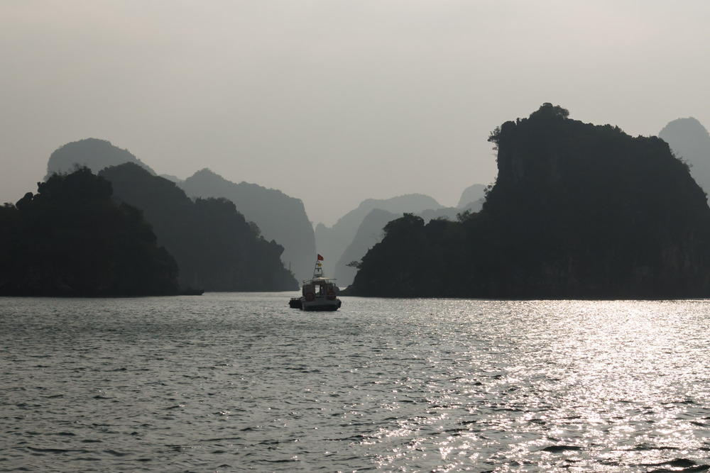 rocks and fishing boat in silhouette