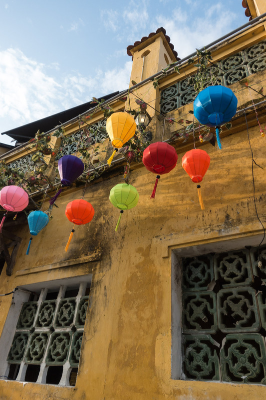 colorful lanterns hanging against a yellow wall