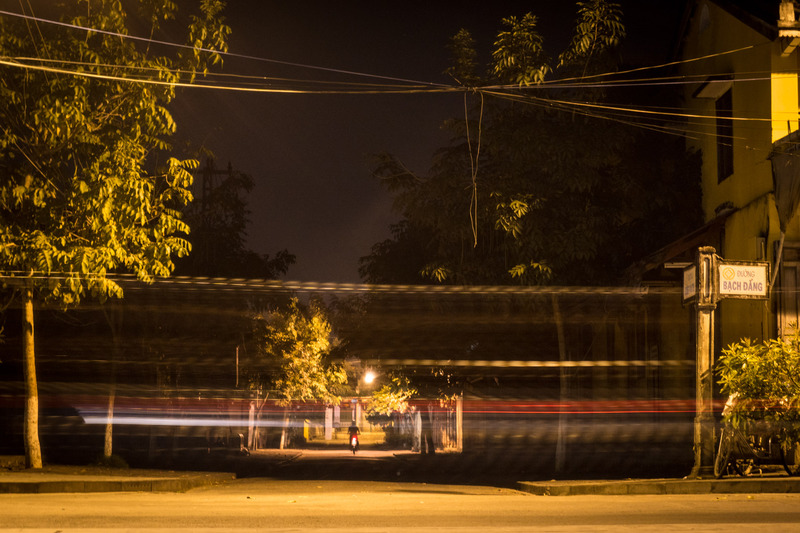 dark street overlaid with motorcycle light trails