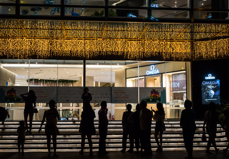 people silhouetted against a department store