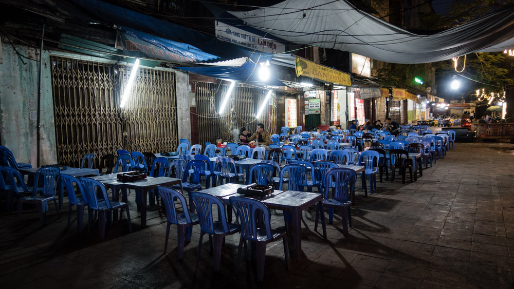 sidewalk restaurant with blue chairs and tables