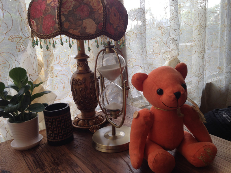 teddy bear and hourglass on the cafe table