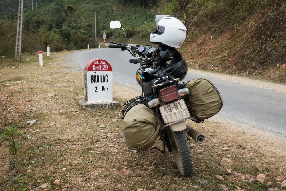 motorbike next to a road marker for Bảo Lạc