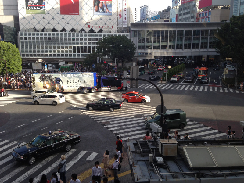 Shibuya crossing, with cars and a Transformer ad