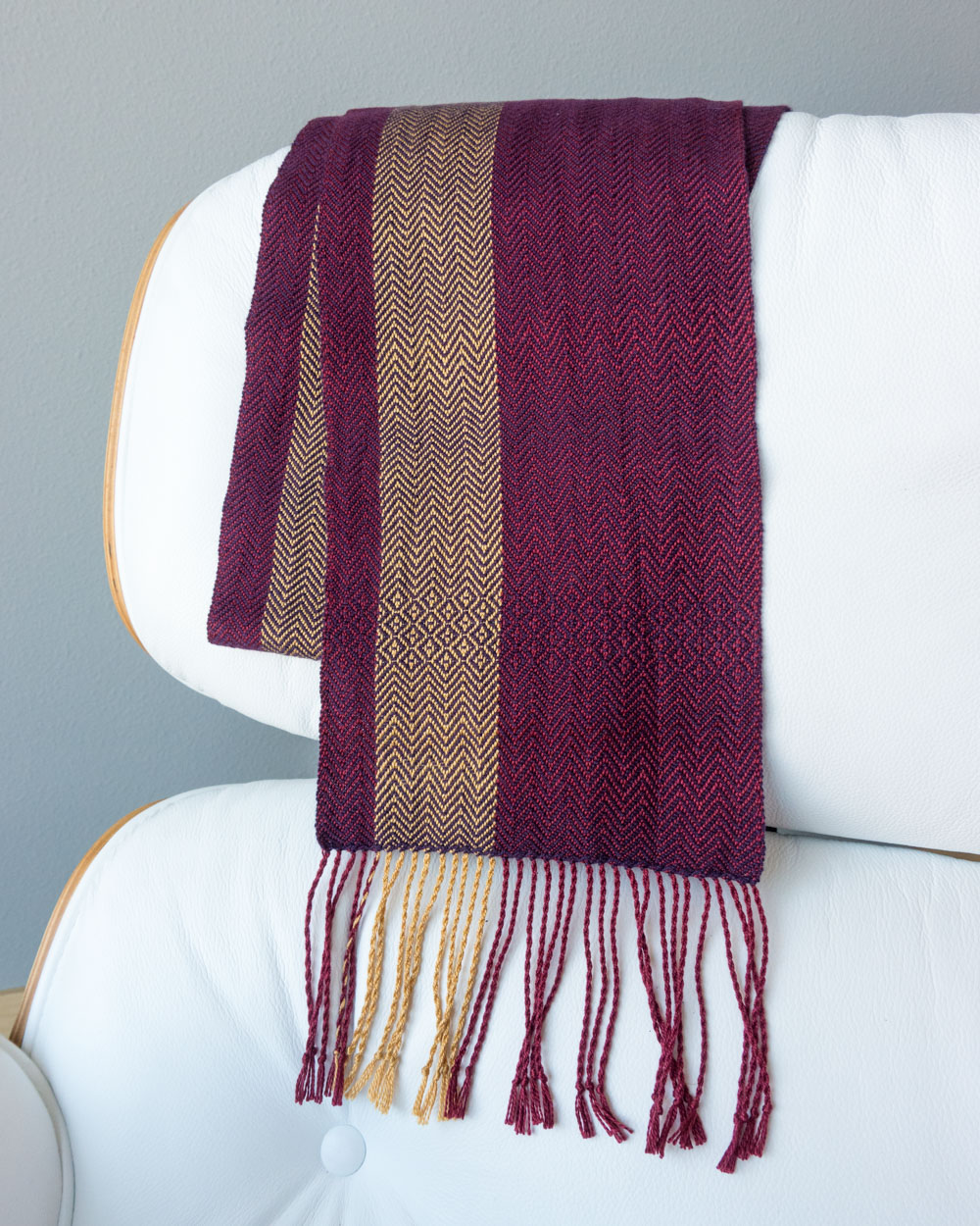 purple and gold scarf draped flat across a chair
