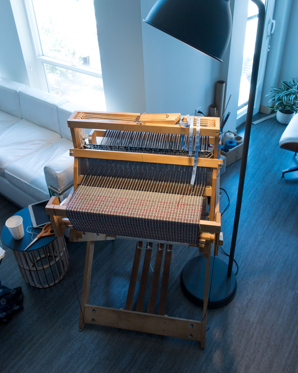 table loom and weaving project illuminated by a lamp