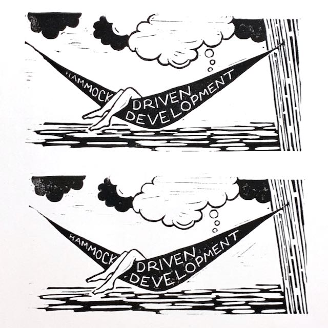 Two identical impressions from the same block. The design reads Hammock-Driven Development, and shows two legs draped over the edge of a hammock stretching out from a tree. Thought clouds stretch above the hammock.