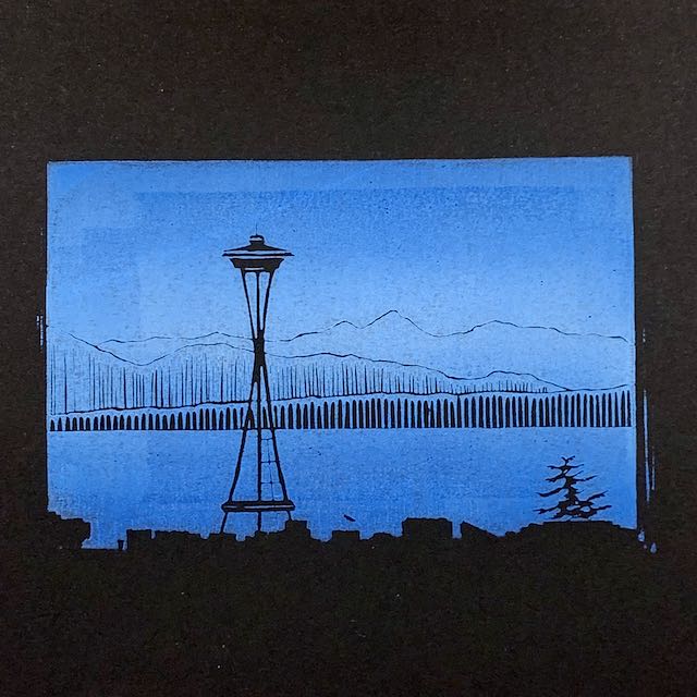 A blue print on black paper, depicting the Space Needle above the Seattle skyline. Puget Sound and the Olympics are in the background.