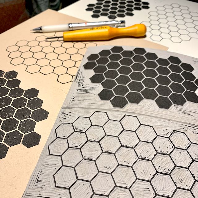 Geometric linoleum block carvings with a repeating hexagon pattern.