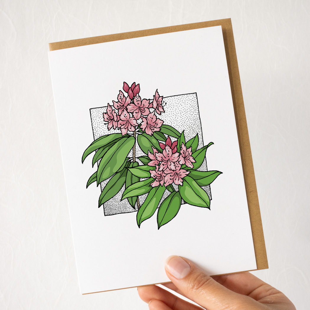 hand holding a white card with a lupine flower, with a brown envelope