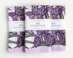 Three rectangular folded kitchen towels, all with the same purple iris pattern and white packaging band