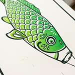 The green koinobori fish seen from an angle, zoomed in to focus on the concentric circles of the eye.
