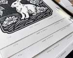 A stack of rabbit blockprints. The paper is heavily textured, and each print is labelled with a hand-written edition number and title.